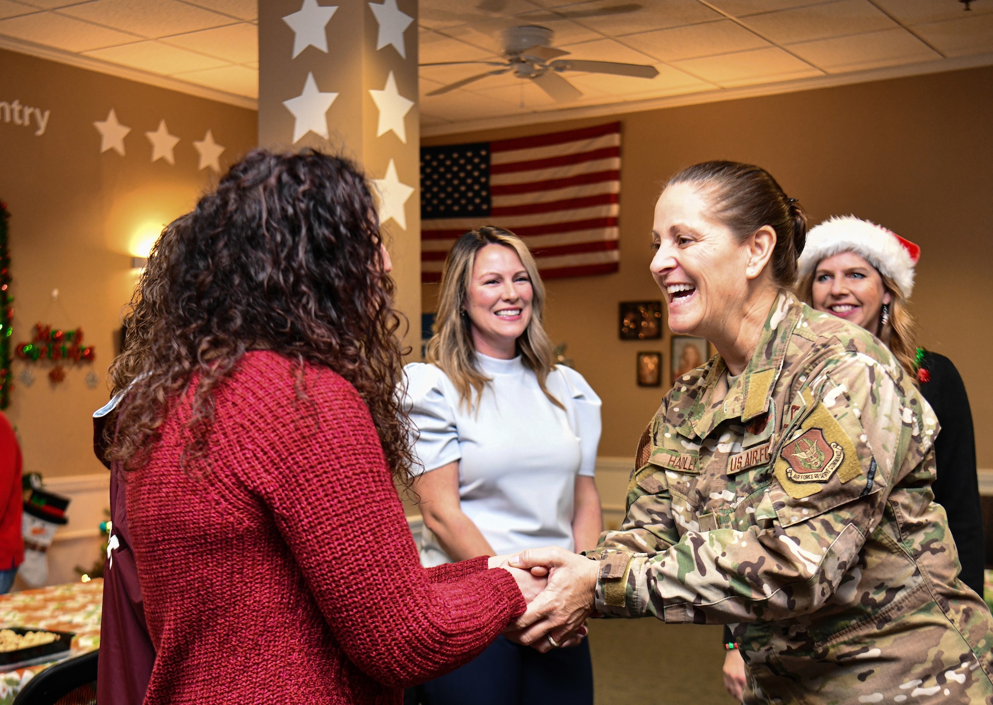 Brig. Gen. Leslie S. Hadley, mobilization assistant to the commander assigned to the 18th Air Force, shakes hands with 910th Airlift Wing Key Spouses during a visit at Youngstown Air Reserve Station, Dec. 3, 2022.