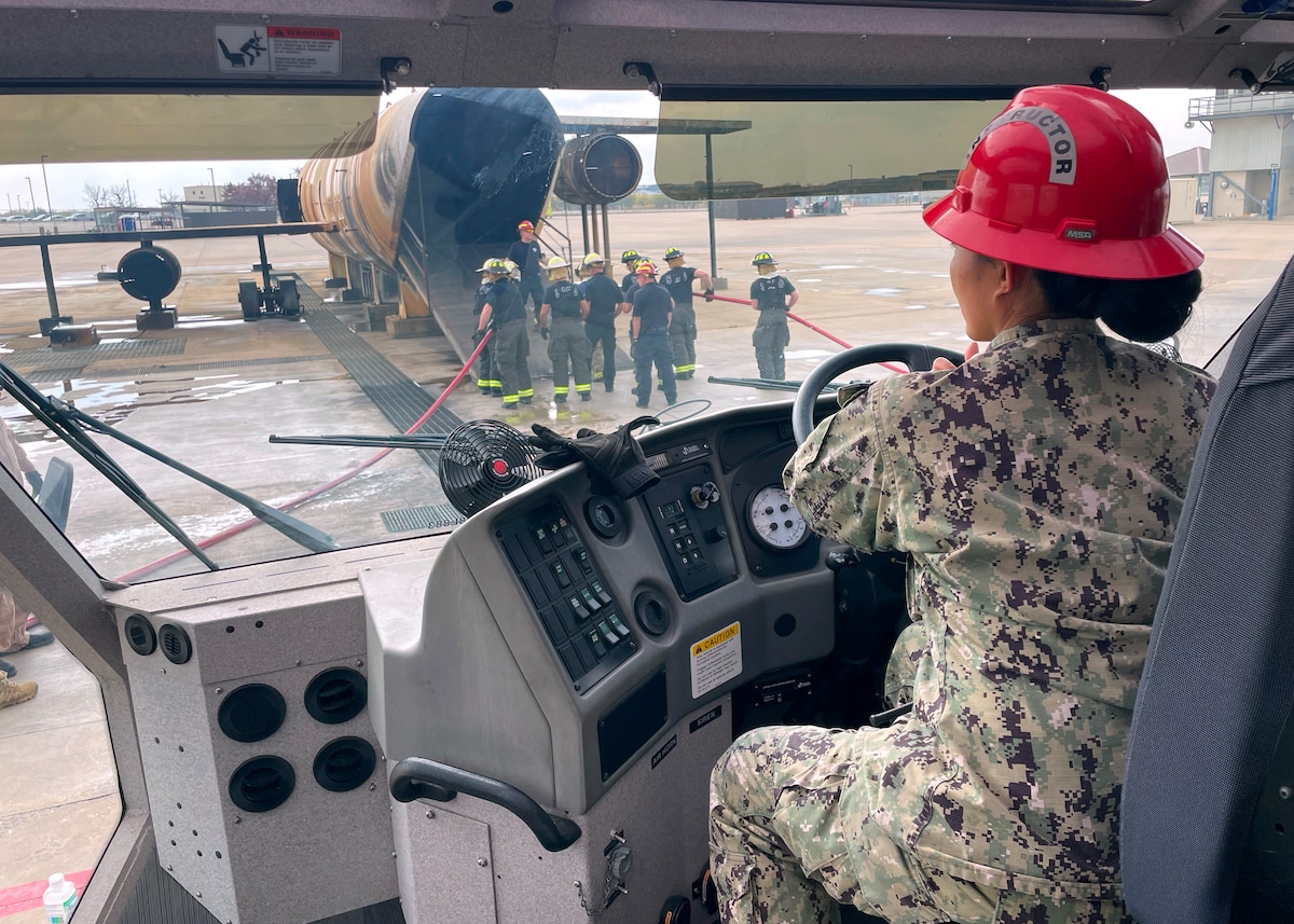 U.S. Navy Chief Petty Officer Diana Gomez, Center for Information Warfare Training Detachment Goodfellow senior Navy instructor, controls water supply to hand lines operated by San Angelo Fire Department during their  Airport Rescue Fire Fighting certification training at the Louis F. Garland Department of Defense Fire Academy, Goodfellow Air Force Base, Texas, Dec. 8, 2022. Goodfellow Air Force Base has more than 54 active community agreements, the most agreements in the Air Education and Training Command. (U.S. Air Force photo by Senior Airman Abbey Rieves)