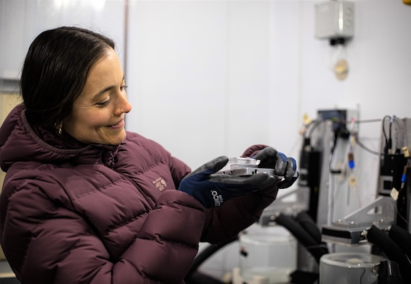 Dr. Emily Asenath-Smith displays an ice laminate grown on a surface using her patented invention, “Vertical draw system and method for surface adhesion of crystalline materials,” which is a foundational component of her ice adhesion research program at the U.S. Army Engineer Research and Development Center’s (ERDC) Cold Regions Research and Engineering Center (CRREL). Asenath-Smith is the lead investigator for CRREL’s Ice Adhesion Facility where much of her innovative research is conducted.