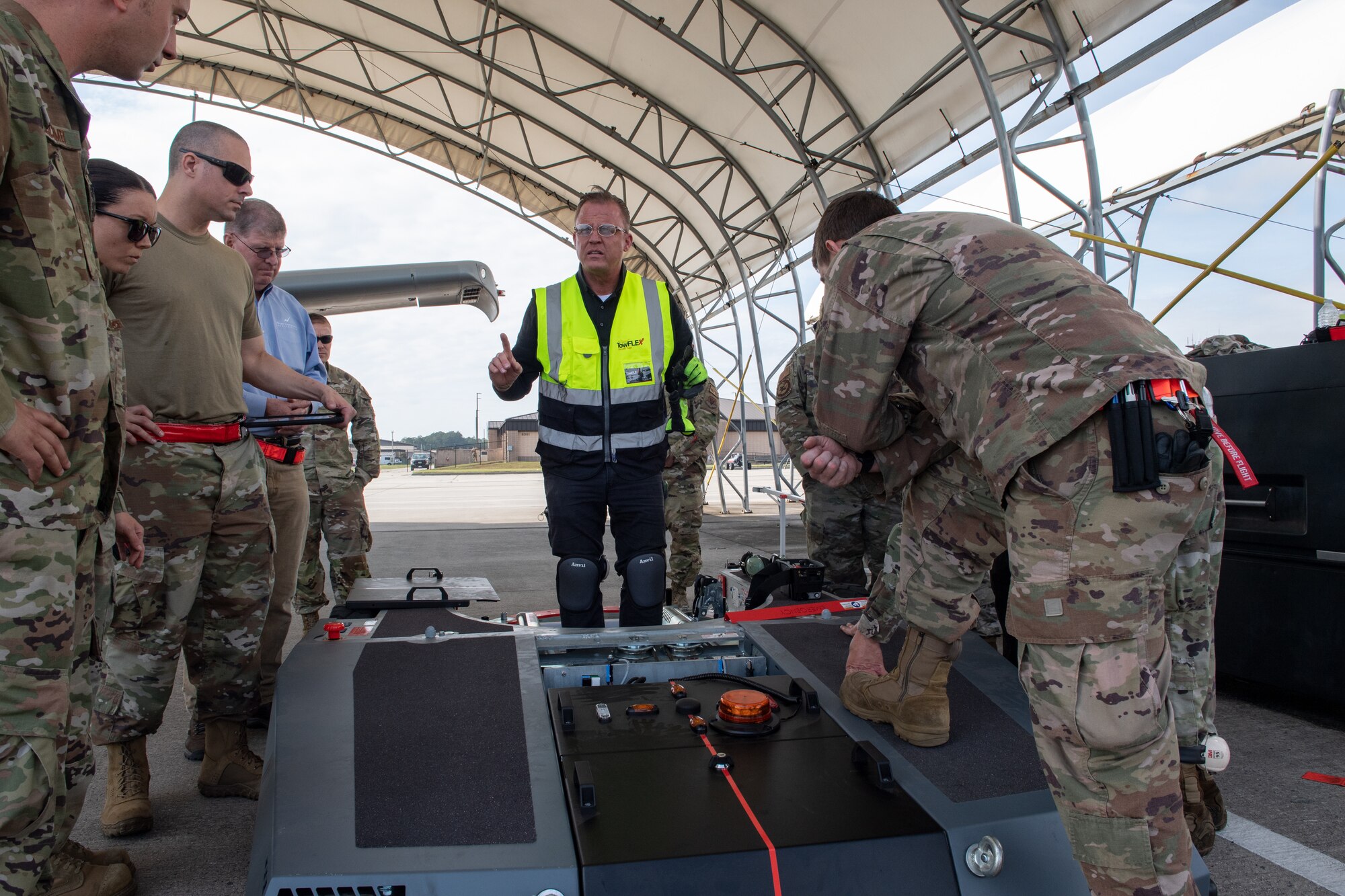 Airmen gather around TowFLEXX.