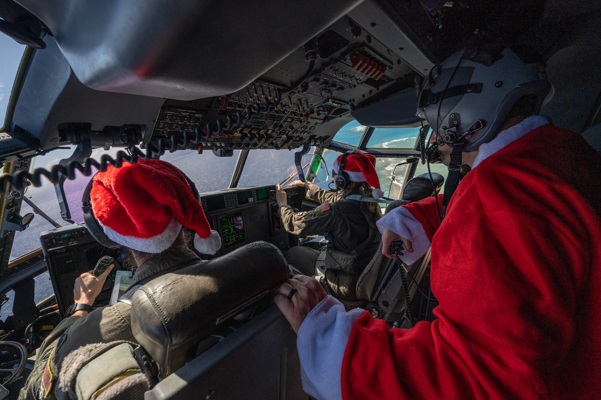 U.S. Air Force Airmen sit in the flight deck of a C-130J Super Hercules