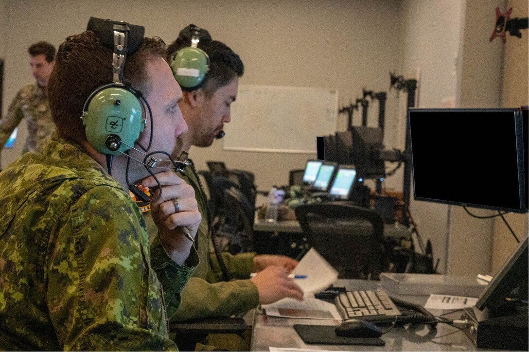 Royal Canadian Air Force Capt. Derek Doerksen (front), and Capt. Dennis Williams, 42 Radar Squadron air battle managers, control a simulated airspace during exercise Swift Strike, Nov. 23, 2022, at Luke Air Force Base, Arizona.