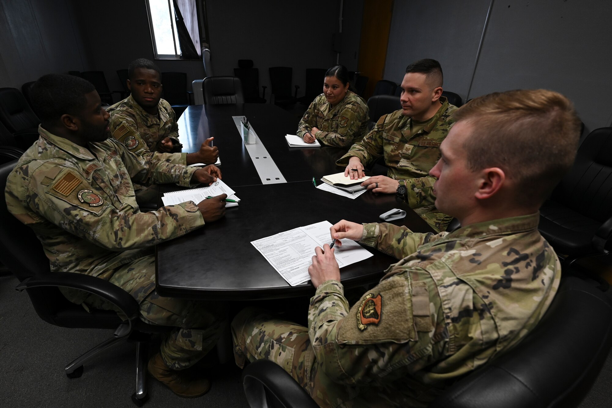 A group of Airmen has a team meeting.