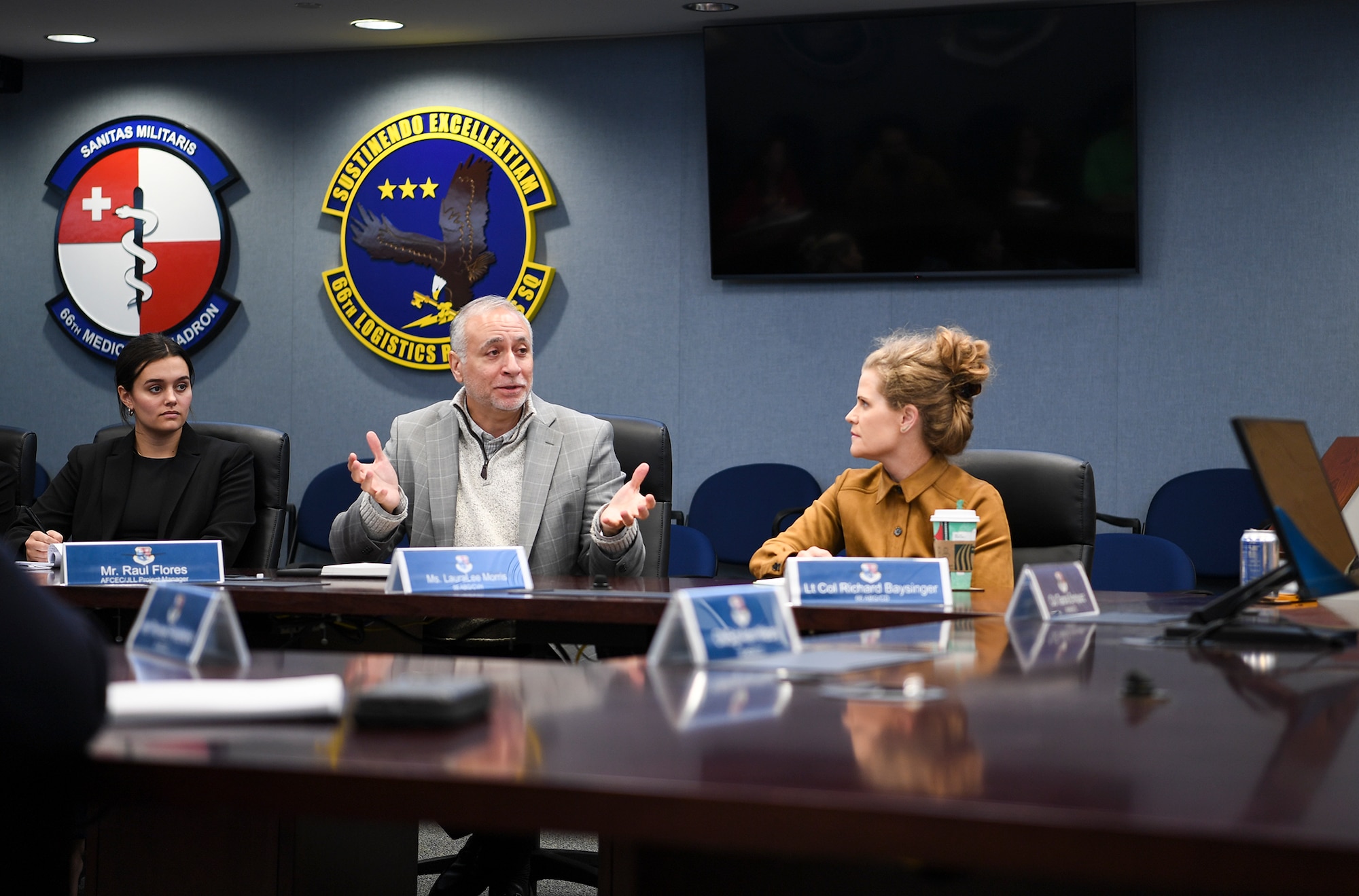 Raul Flores sits at the conference table, explains the findings, briefs senior leaders, and takes questions