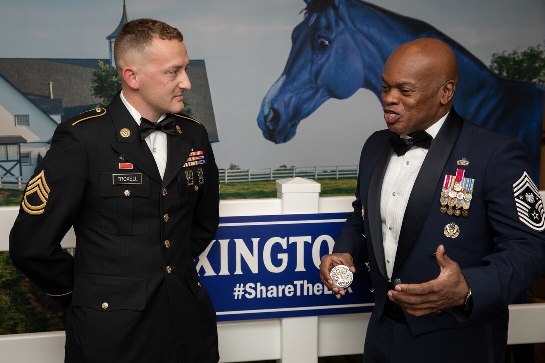 Senior Enlisted Advisor Tony Whitehead (right) presents his coin to Army Sgt. First Class James Troxell (left) at the 138th Field Artillery Brigade annual ball in Lexington, Ky. on Dec. 3, 2022. Whitehead is visiting soldiers and airmen in the Kentucky National Guard before the holidays. (U.S. Army photo by Staff Sgt. Andrew Dickson)