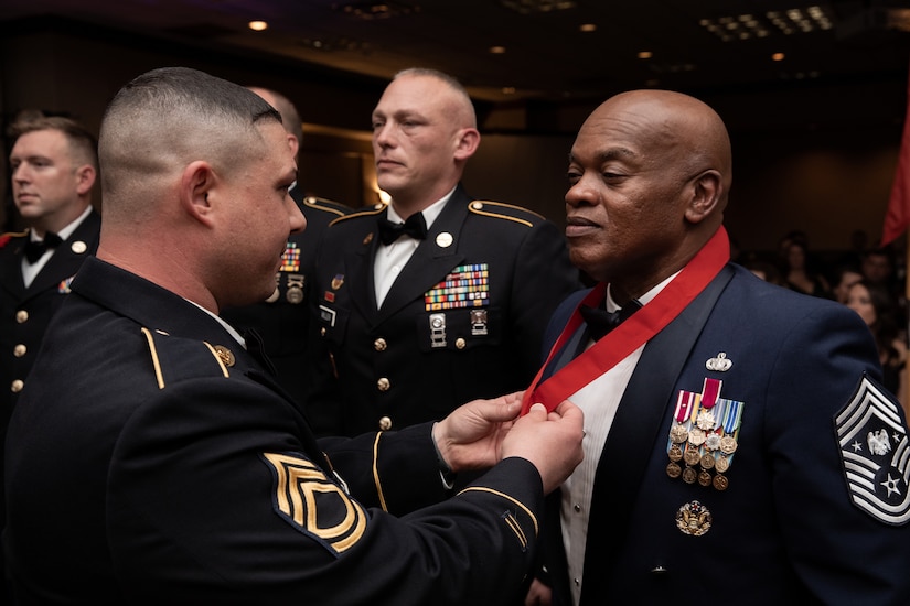 Senior Enlisted Advisor Tony Whitehead (right) is presented the Order of St. Barbara by Army Sgt. First Class Chris Praino at the 138th Field Artillery Brigade annual ball in Lexington, Ky. on Dec. 3, 2022. Whitehead was nominated by Praino into the order after 40 years of military service. (U.S. Army photo by Staff Sgt. Andrew Dickson)