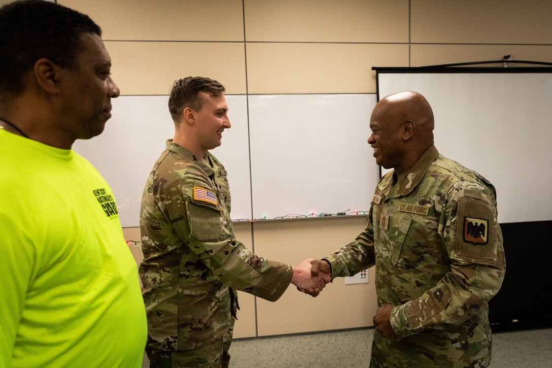 National Guard Senior Enlisted Advisor Tony Whitehead gives a coin to Army Sgt. Kevin Brierly of the 101st Airborne Division, Main Command Post Operation Detachment, 75th Troop Command in Bowman Field Armory in Louisville, Ky. on Dec. 4, 2022. Whitehead visited Kentucky to recognize Soldiers for their work throughout the year. (U.S. Army photo by Staff Sgt. Andrew Dickson)