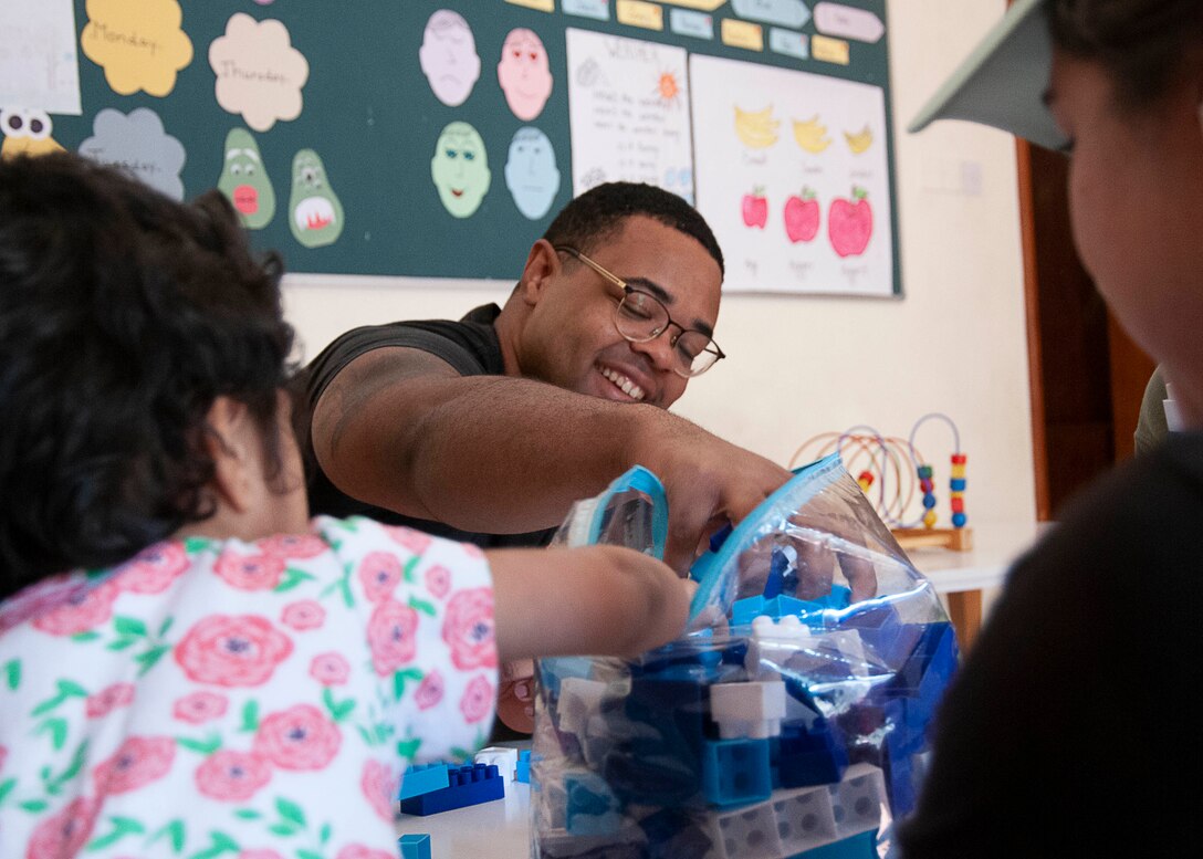 MANAMA, Bahrain (Dec. 12, 2022) Information Systems Technician 2nd Class Brandon Kee, from U.S. Naval Forces Central Command/U.S. 5th Fleet, interacts with students at a learning center in Bahrain, Dec. 12, during a community service event.