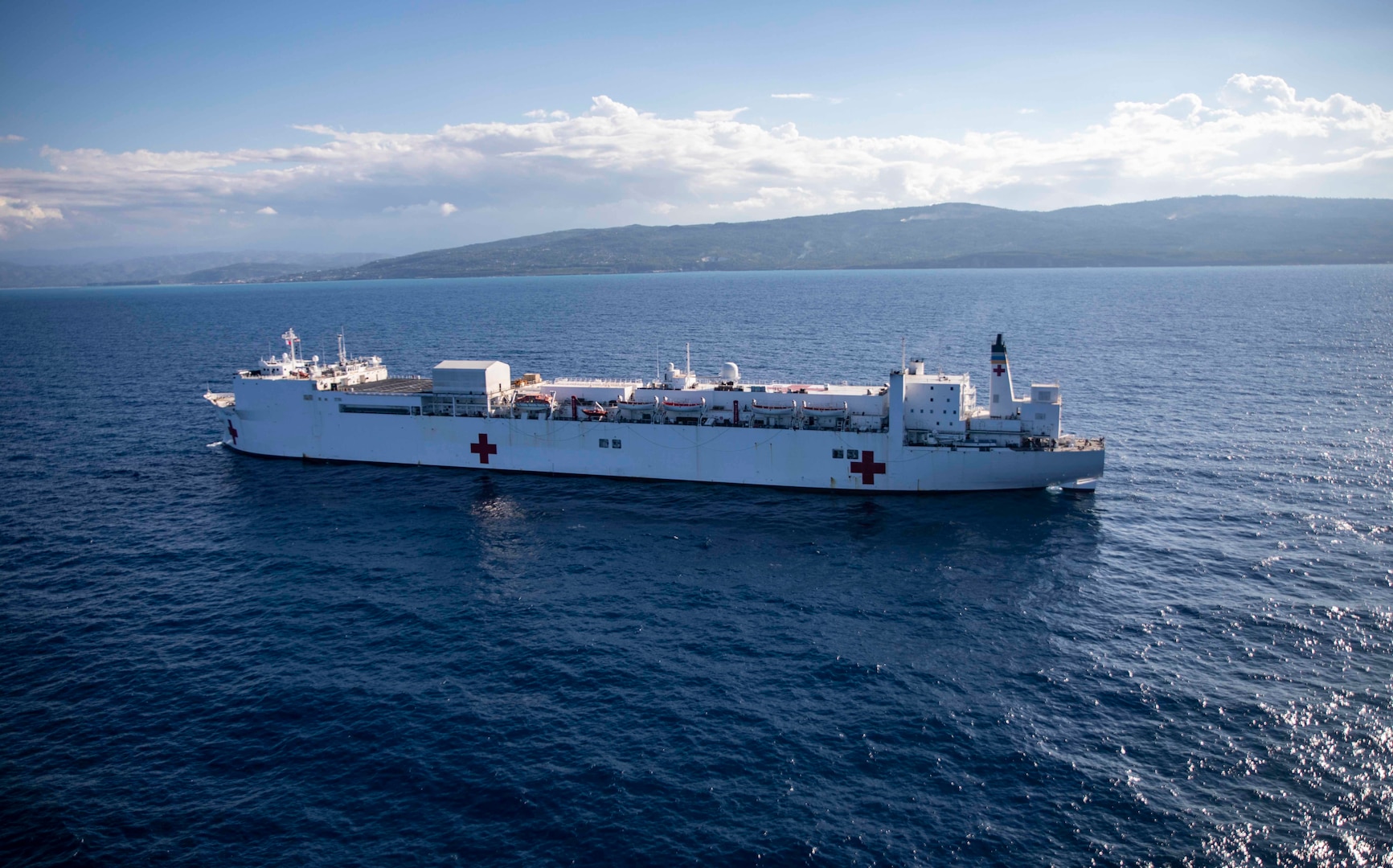 Hospital ship USNS Comfort (T-AH 20) sails off the coast of Jeremie, Haiti, Dec. 11, 2022. Comfort is deployed to U.S. 4th Fleet in support of Continuing Promise 2022, a humanitarian assistance and goodwill mission conducting direct medical care, expeditionary veterinary care, and subject matter expert exchanges with five partner nations in the Caribbean, Central and South America.