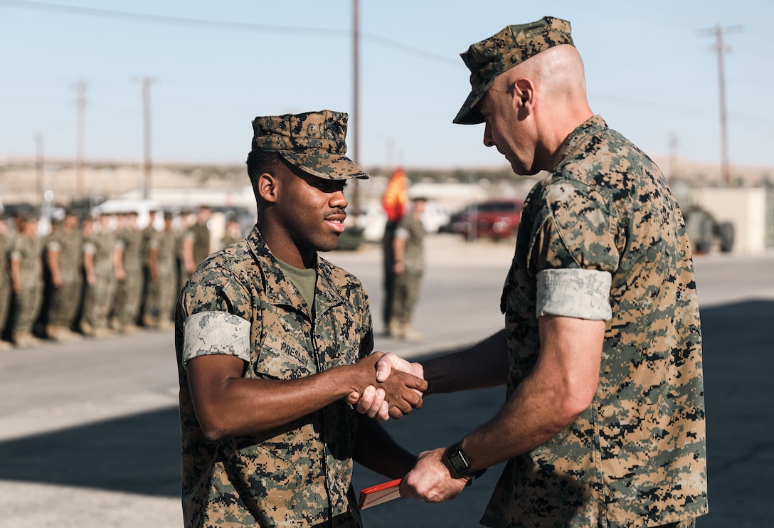 U.S. Marine Corps Lt. Col. John A. McNulty (Right), battalion commander, with 3rd Battalion, 11th Marine Regiment, 1st Marine Division, awards Lance Cpl. Michael A. Presley, a cannoneer with the battalion, the Navy and Marine Corps Achievement Medal during a battalion formation at Marine Corps Air Ground Combat Center, Twentynine Palms, California, May 23, 2022. Presley was awarded the Navy and Marine Corps Achievement Medal for saving the occupants of a flipped over vehicle near Palm Springs, California, in October 2021. Presley is a native of Buncombe County, North Carolina. (U.S. Marine Corps photo by Cpl. Shane T. Beaubien)