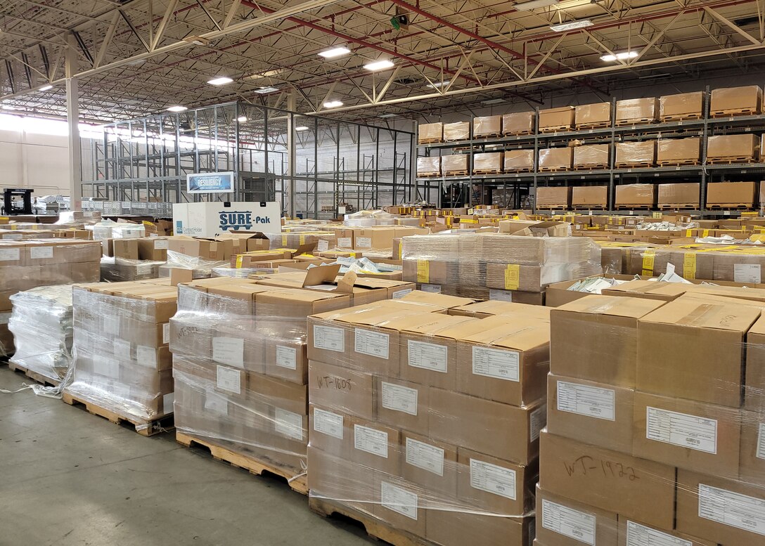 View is an interior shot of a warehouse with lots of boxes that take up a lot of space.