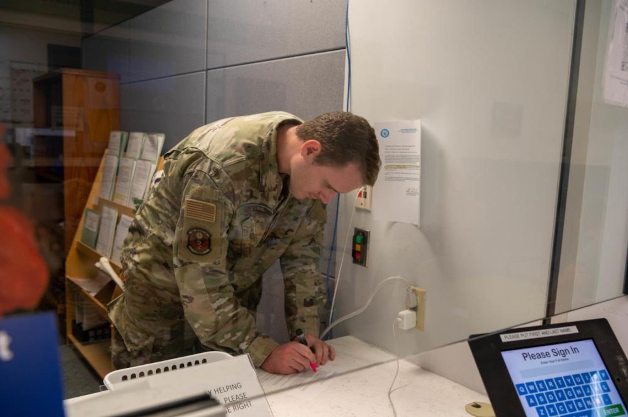 U.S. Air Force SrA Qwinton Odom, 1st Special Operations Medical Group, diagnostic imaging technologist, assists a patient to check in for an appointment at Hurlburt Field, Fla., Nov. 8, 2022. The Military Health System Genesis Electronic Health Record System is a new electronic health record system that will decrease wait times for patients and improve functionality.