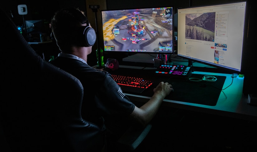 A man faces computer monitors while playing a game.