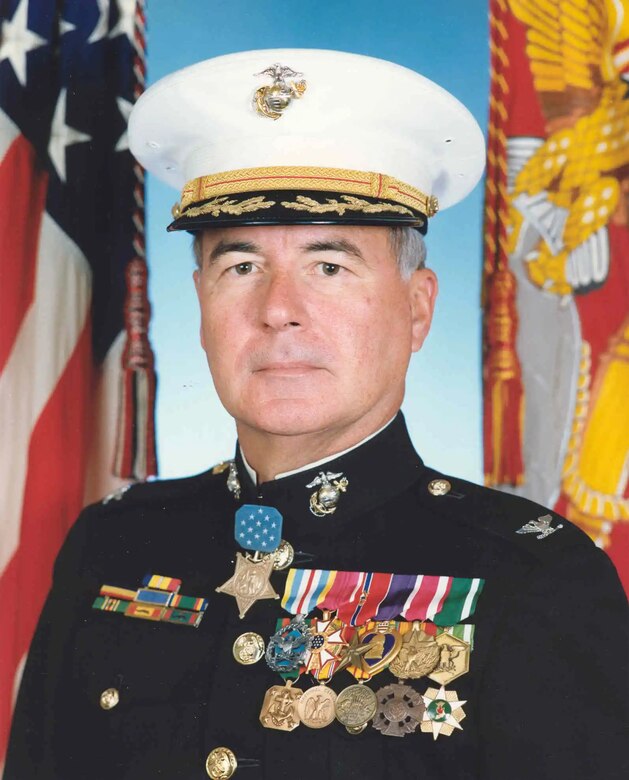 A man in a decorated uniform poses for a photo.
