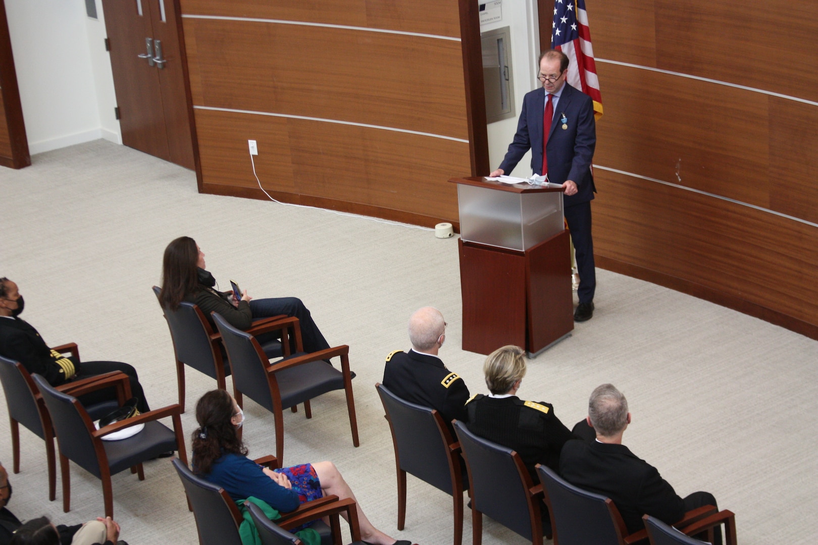 Dr. Louis French (standing at podium), deputy director of the National Intrepid Center of Excellence (NICoE), thanks his family, friends and colleague for their support after he was awarded the Department of Defense’s (DOD) Medal for Distinguished Civilian Service by Army Lt. Gen. (Dr.) Ronald J. Place, director of the Defense Health Agency (DHA), Dec. 2.