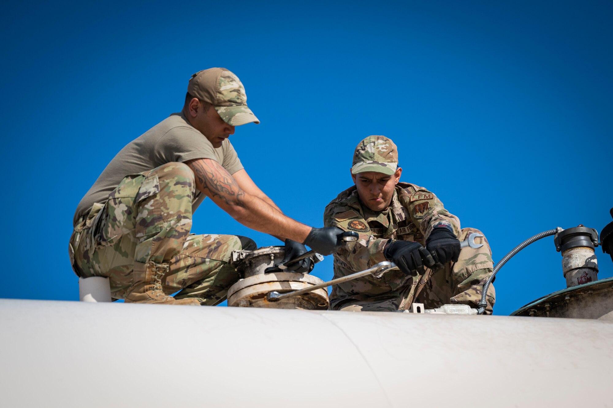Senior Airman Justin Bellivan, left, and Staff Sgt. Christian Munoz-Alvarez, 4th Civil Engineer Squadron liquid fuels maintenance technicians, replace an emergency vent on a fuel tank at Seymour Johnson Air Force Base, North Carolina, Dec. 13, 2022. The replacement was made to keep the fuel tanks up to standard.