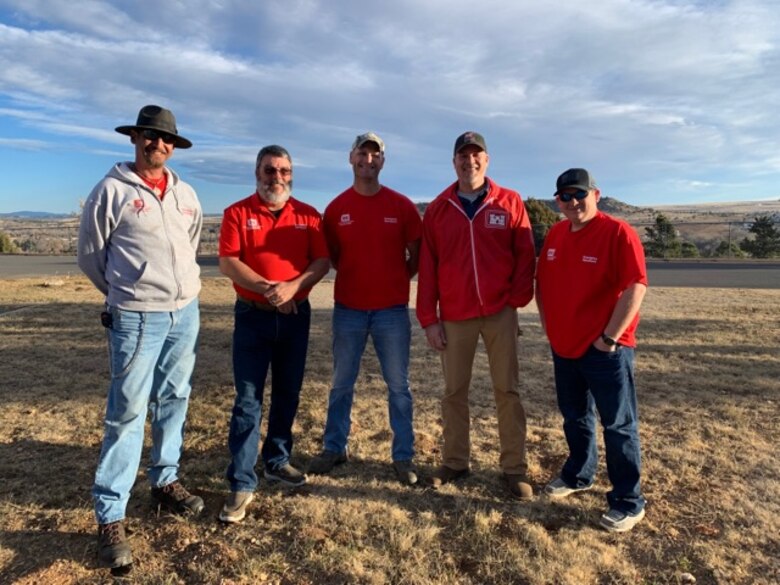 Five men standing in a field.