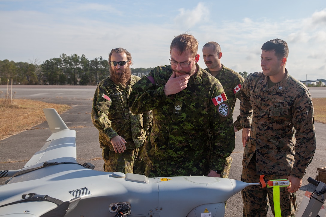 U.S. Marine Corps Capt. Daniel Renner (right), a pilot with Marine Unmanned Aerial Vehicle Squadron (VMU) 2, and Canadian soldiers with the 4th Artillery Regiment (General Support) examine an RQ-21 Blackjack at Marine Corps Air Station Cherry Point, North Carolina, Dec. 8, 2022. VMU-2 trained with the Canadian Army to increase collective proficiency in the Viper software program. VMU-2 is a subordinate unit of 2nd Marine Aircraft Wing, the aviation combat element of II Marine Expeditionary Force. (U.S. Marine Corps photo by Caleb Stelter)