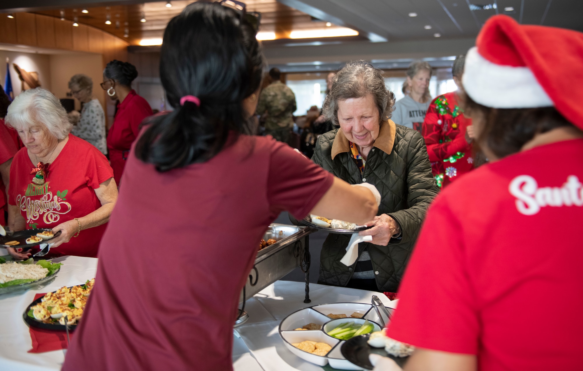 The 325th Force Support Squadron Oasis Event Center staff serves food to senior citizen veterans at Tyndall Air Force Base, Florida, Dec. 9, 2022. Tyndall hosted the 32nd Annual Golden Age Holiday Party, which honors senior citizen veterans from World War II, the Korean War, Vietnam War and Desert Storm eras. (U.S. Air Force photo by Staff Sgt. Cheyenne Lewis)