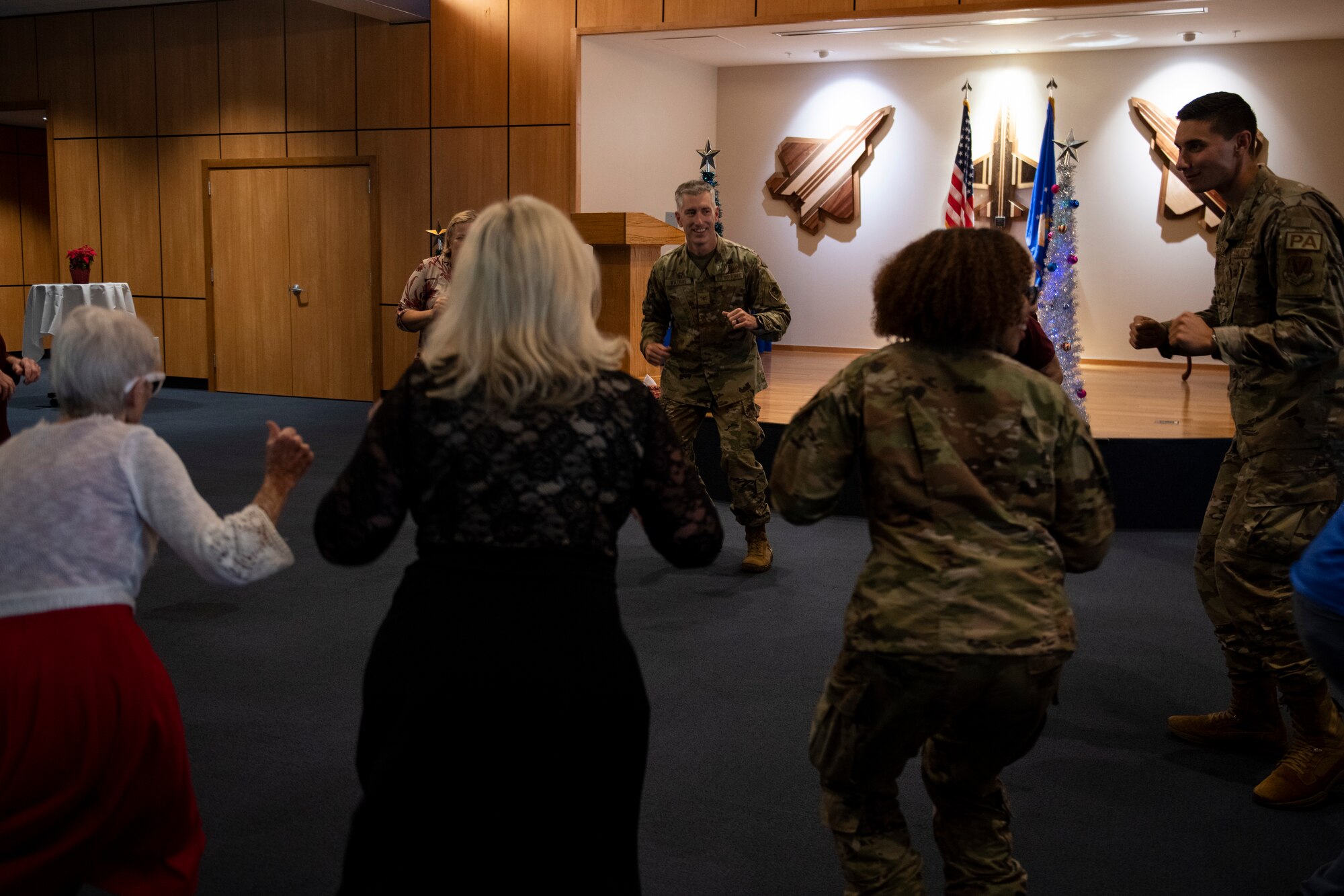 U.S. Air Force Col. George Watkins, 325th Fighter Wing commander, center, Airmen assigned to Tyndall, and senior citizen veterans dance at Tyndall Air Force Base, Florida, Dec. 9, 2022.