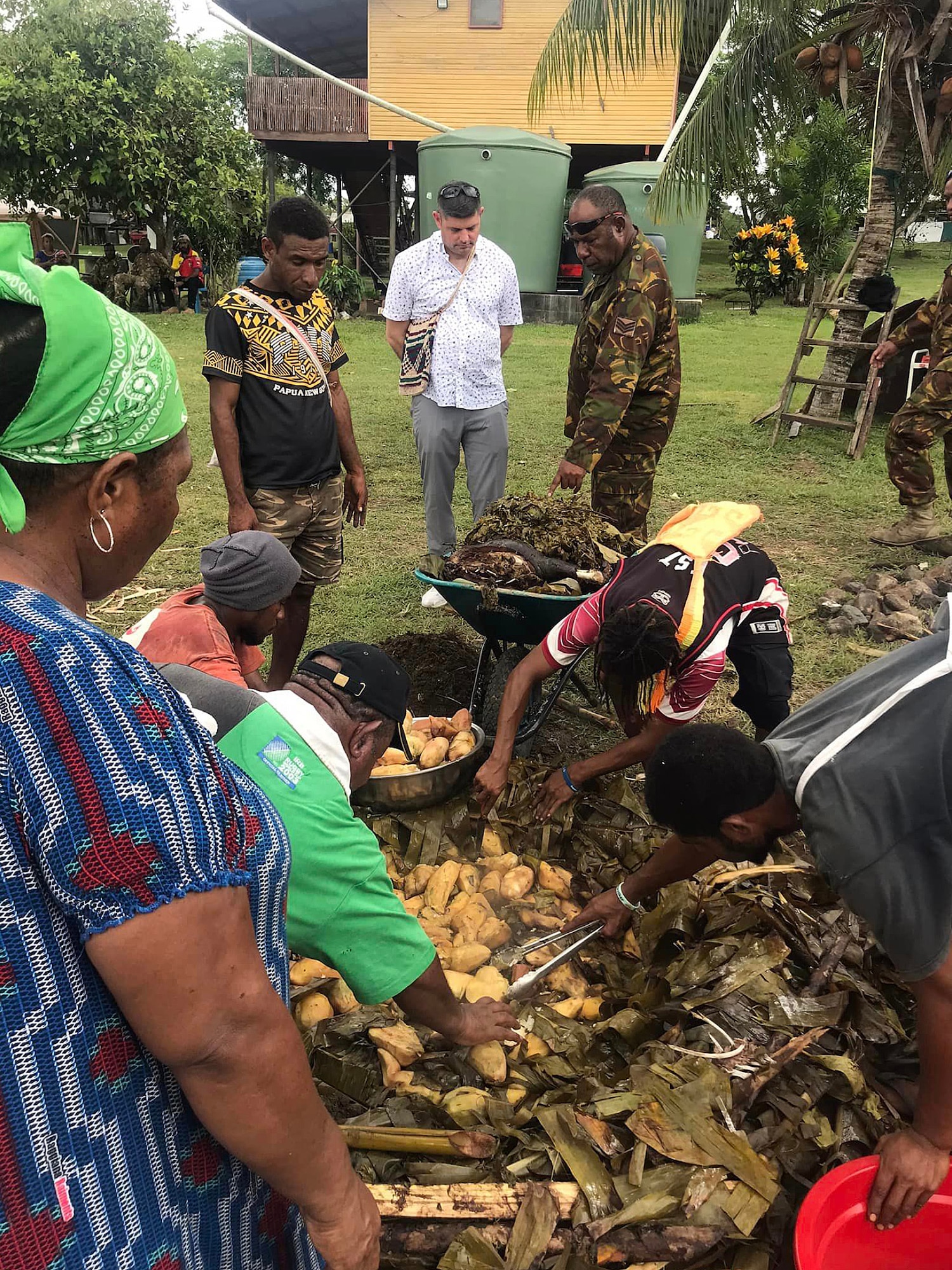 Villagers in Boregaina, the home of Maj. Gen. Mark Goina, chief of the Papua New Guinea Defence Force, extract sweet potatoes and roasted meat from a cooking pit during a traditional mumu, or ceremonial meal, Dec. 3, 2022. The mumu was prepared in honor of a Wisconsin National Guard delegation to Papua New Guinea for the official signing of a State Partnership Program agreement.