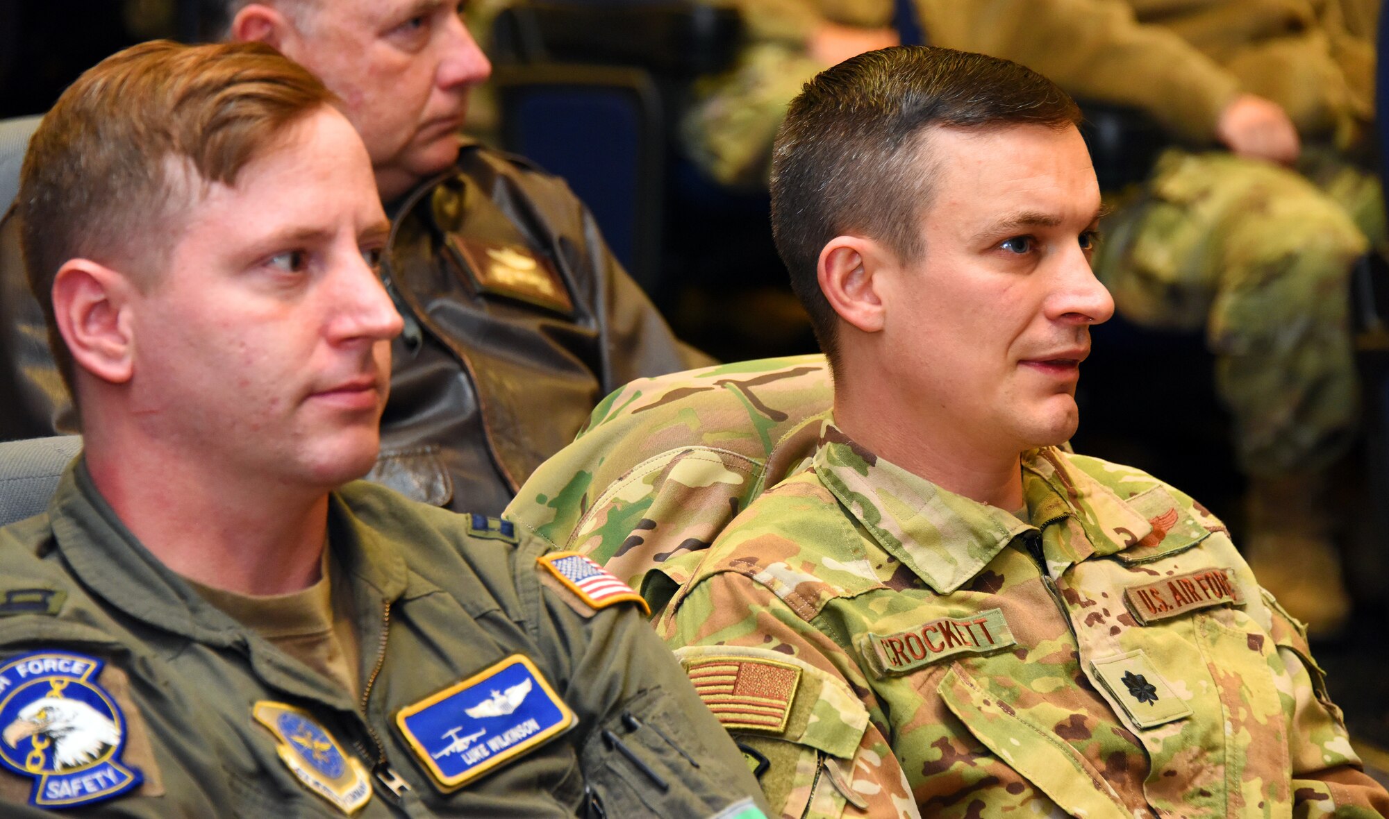 U.S. Air Force Capt. Luke Wilkinson, 305th Air Mobility Wing flight safety officer, and U.S. Air Force Lt. Col. Joshua Crockett, 305th Air Mobility Wing Chief of Safety, listen to a speaker at the symposium.