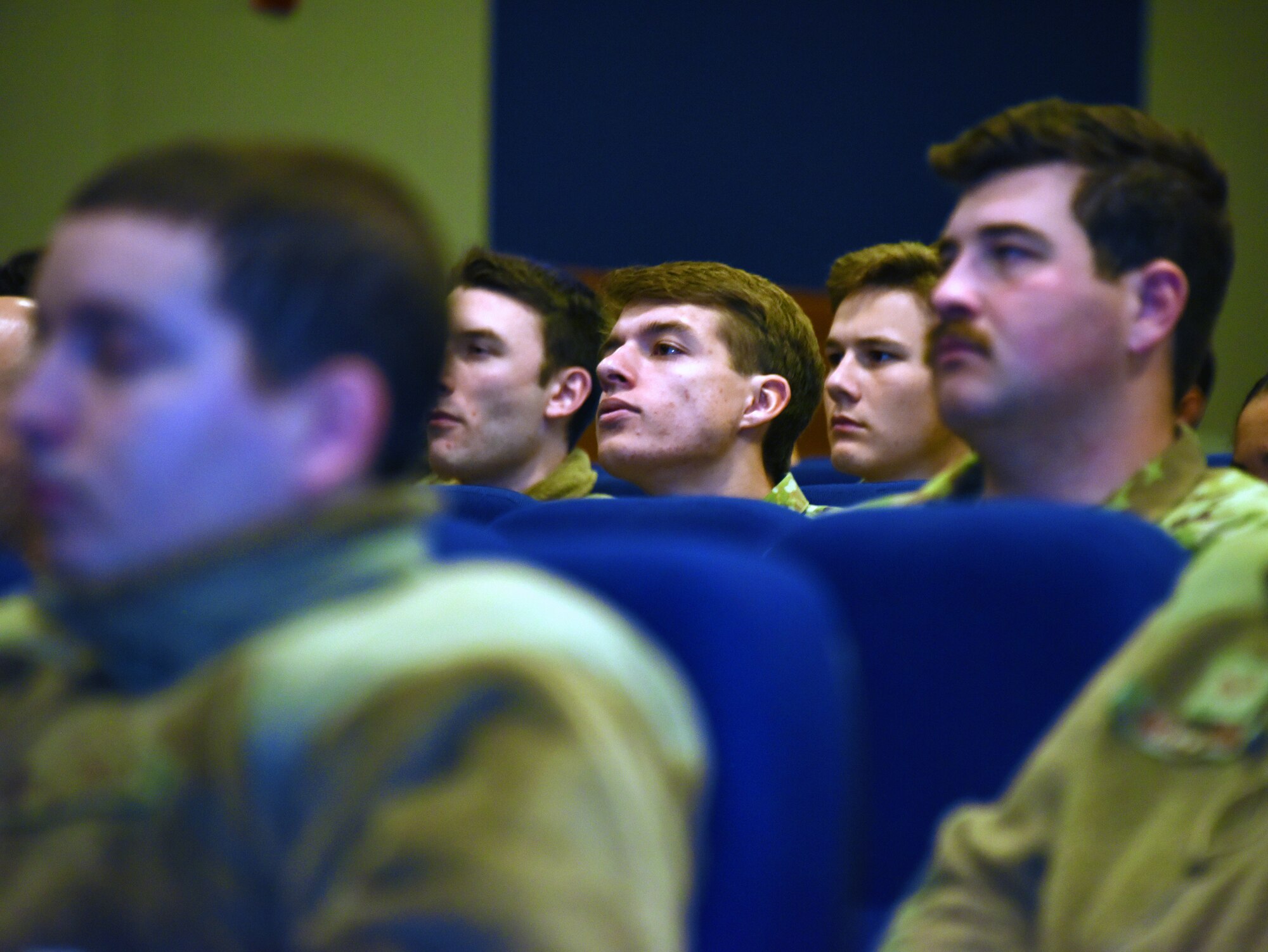 Airmen listen to a speaker giving a lecture at the symposium.