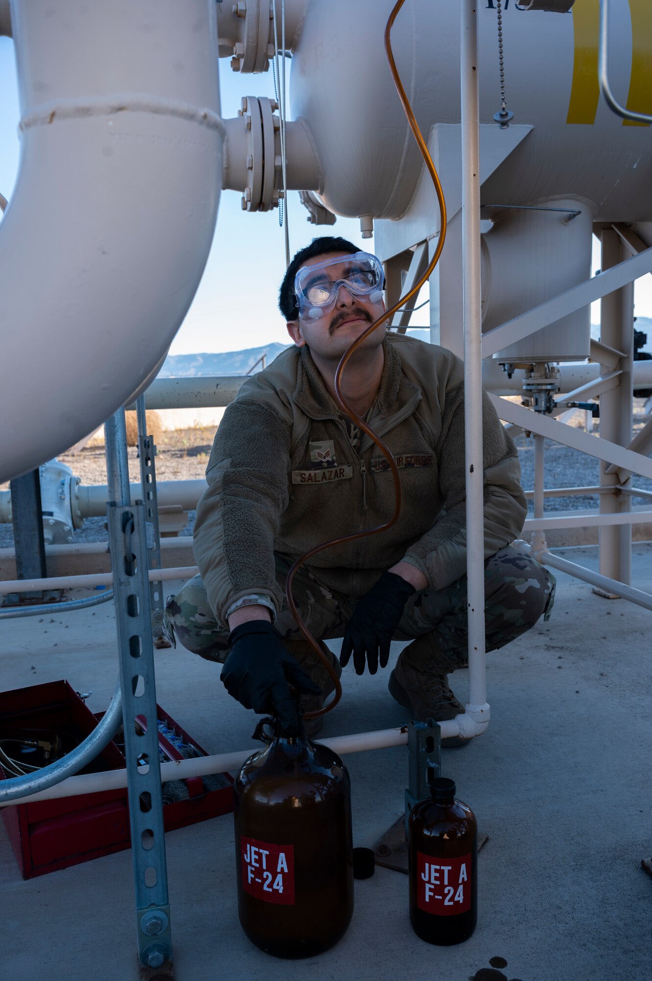 U.S. Air Force Senior Airman Jose Salazar, 49th Logistics Readiness Squadron fuels laboratory technician, gathers samples of jet fuel from the aviation inventory at Holloman Air Force Base, New Mexico, Dec. 12, 2022. The 49th LRS fuels laboratory stores approximately 1.3 million gallons of fuel and receives around 60,000 gallons of fuel each day from local distributors. (U.S. Air Force photo by Airman 1st Class Isaiah Pedrazzini)