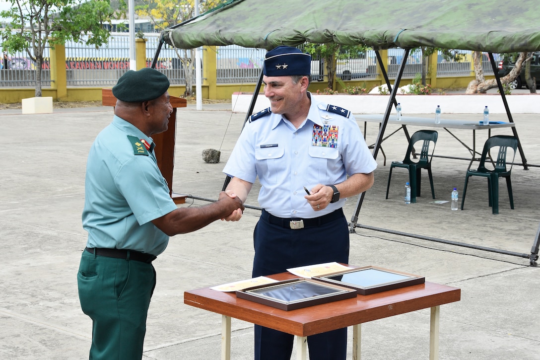 Maj. Gen. Paul Knapp, Wisconsin’s adjutant general, and Maj. Gen. Mark Goina, chief of the Papua New Guinea Defence Force, shake hands after signing a State Partnership Program agreement Dec. 2, 2022, in Port Moresby, Papua New Guinea.