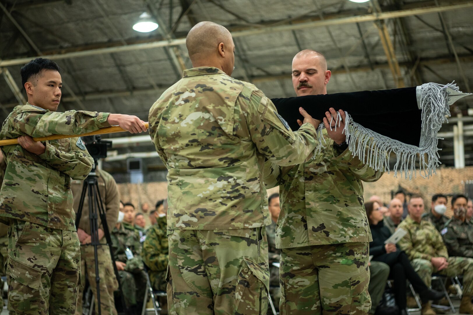 U.S. Space Force Lt. Col. Joshua McCullion, U.S. Space Forces Korea inaugural commander, unfurls the USSFK flag during the unit’s activation ceremony at Osan Air Base, Republic of Korea, Dec. 14, 2022. The newly activated USSFK will be tasked with coordinating space operations and services such as missile warning, position navigation and timing, and satellite communications within the region.