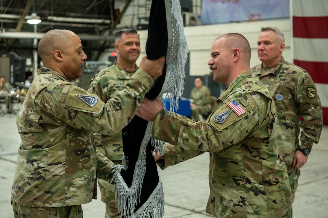 U.S. Space Force Lt. Col. Joshua McCullion, U.S. Space Forces Korea inaugural commander, passes the guidon to U.S. Space Force Master Sgt. Cederic Hill, USSFK senior enlisted leader, during the USSFK activation ceremony at Osan Air Base, Republic of Korea, Dec. 14, 2022. The newly activated USSFK will be tasked with coordinating space operations and services such as missile warning, position navigation and timing, and satellite communications within the region.
