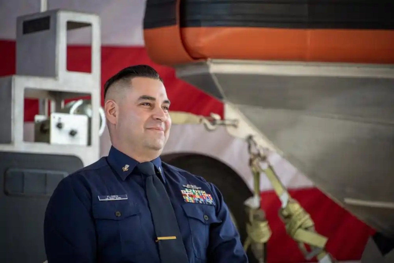 Coast Guard Petty Officer 2nd Class Jake Flores, maritime enforcement specialist at Maritime Safety & Security Team Houston and 2022 USO Service Member of the Year honoree, beams during a ceremony in Houston, Texas, Dec. 1, 2022. Flores’s command nominated him for the award for jumping into the Rio Grande to save a drowning baby during a patrol on June 2, 2022. (U.S. Coast Guard photo by Petty Officer 1st Class Corinne Zilnicki)
