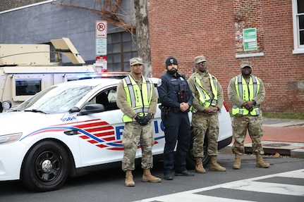 Partnership is everything: Capital Guardians and Washington Metropolitan Police Dept. officer stand ready at their designated traffic control point.