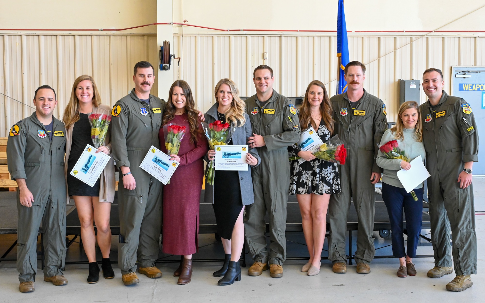 Pictured above is a group of people posing for a photo during a ceremony.