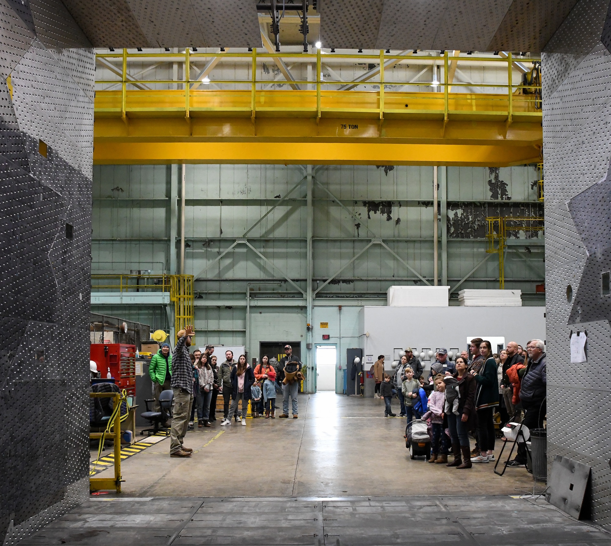 Groups of people standing inside large industrial building