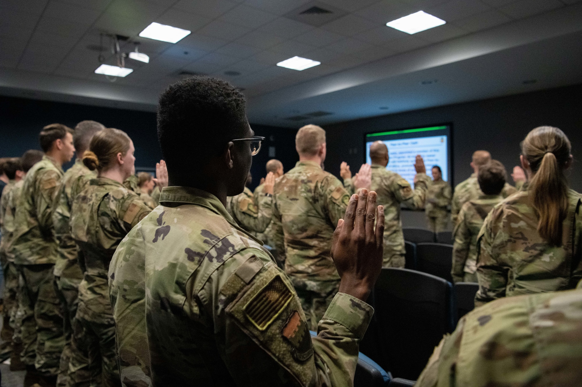 Airmen attending the peer support program foundational training recite an oath prior to accepting their duties.