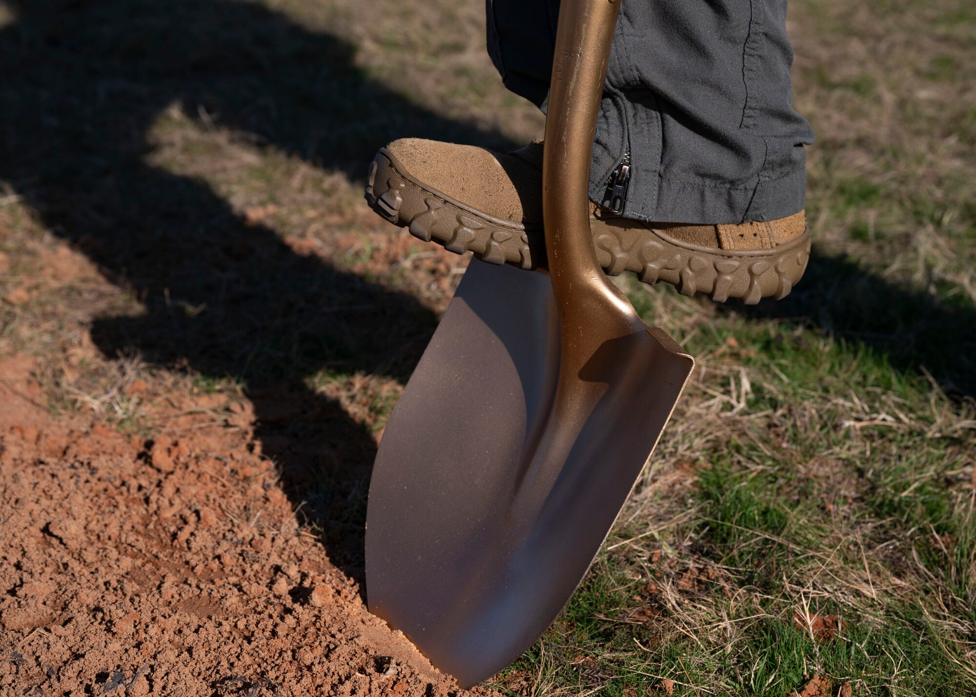 20th Fighter Wing Col. stands on shovel during an Arbor Day ceremony