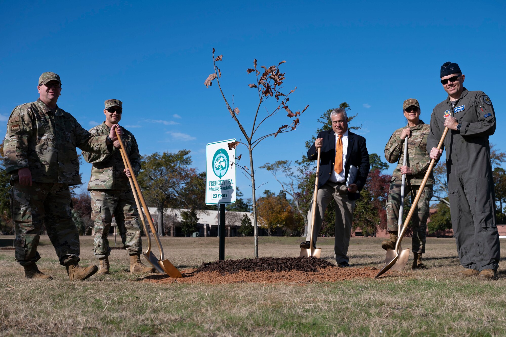 20th Fighter Wing leadership pose for a photo with ceremonial shovels during an Arbor Day ceremony
