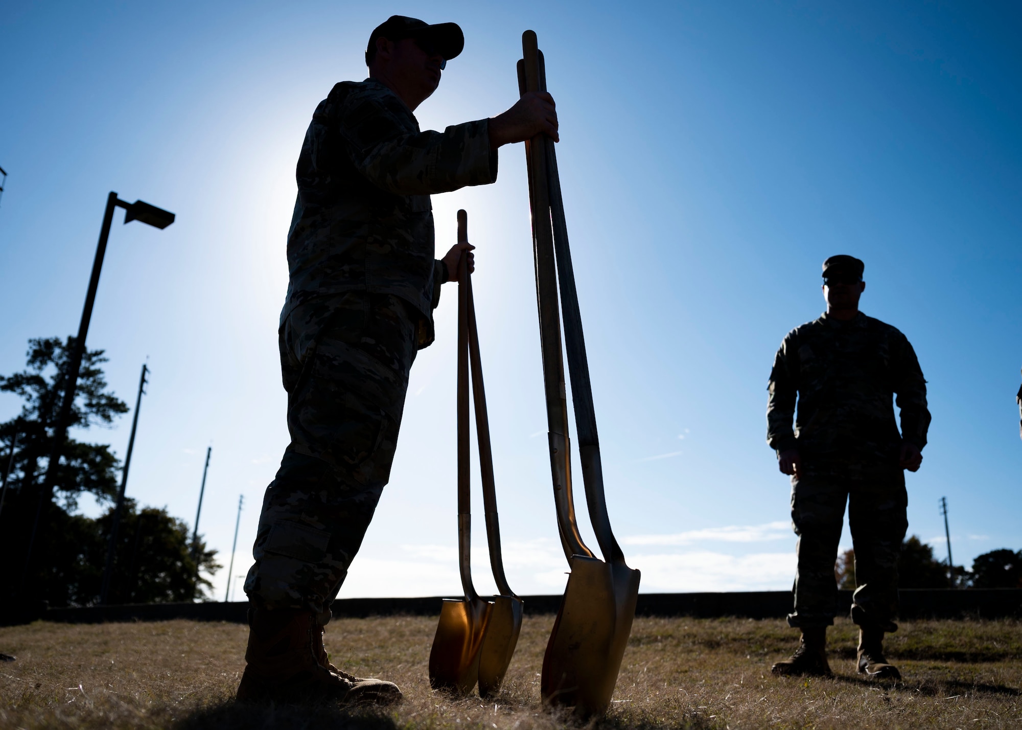 Airman holds ceremonial shovels after Arbor Day ceremony