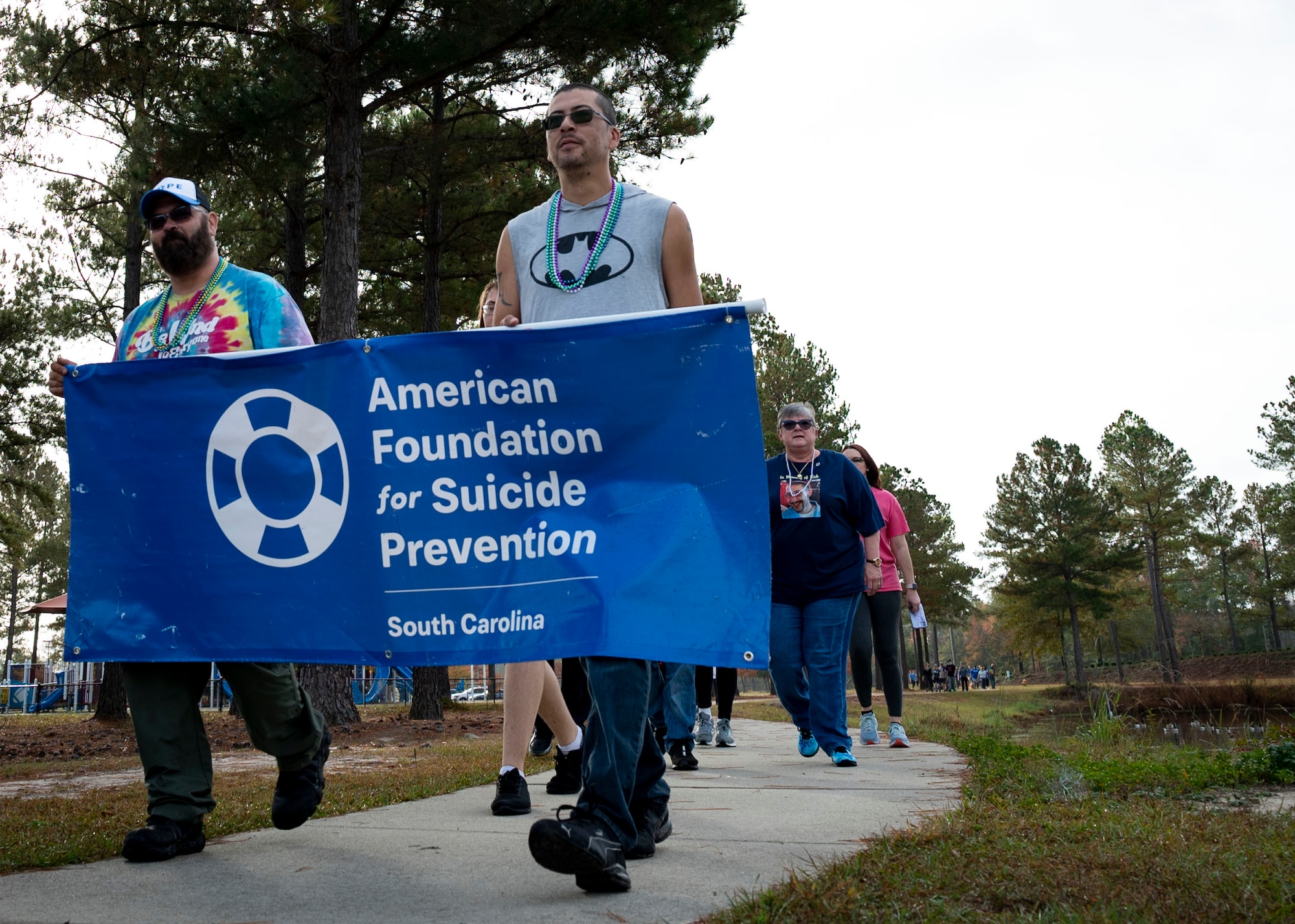 Out of the Darkness walk participants carry the AFSP banner while walking