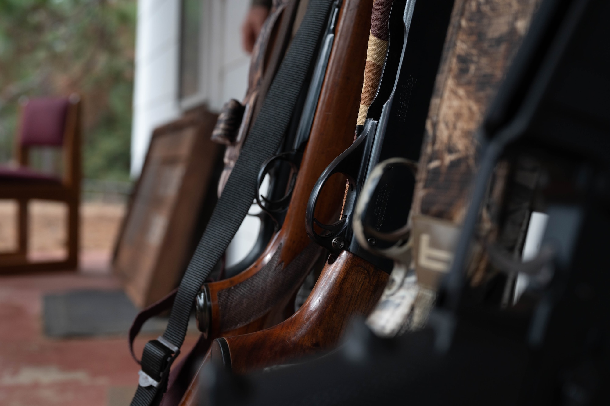 Hunting rifles rest on a gun rack awaiting retrieval.