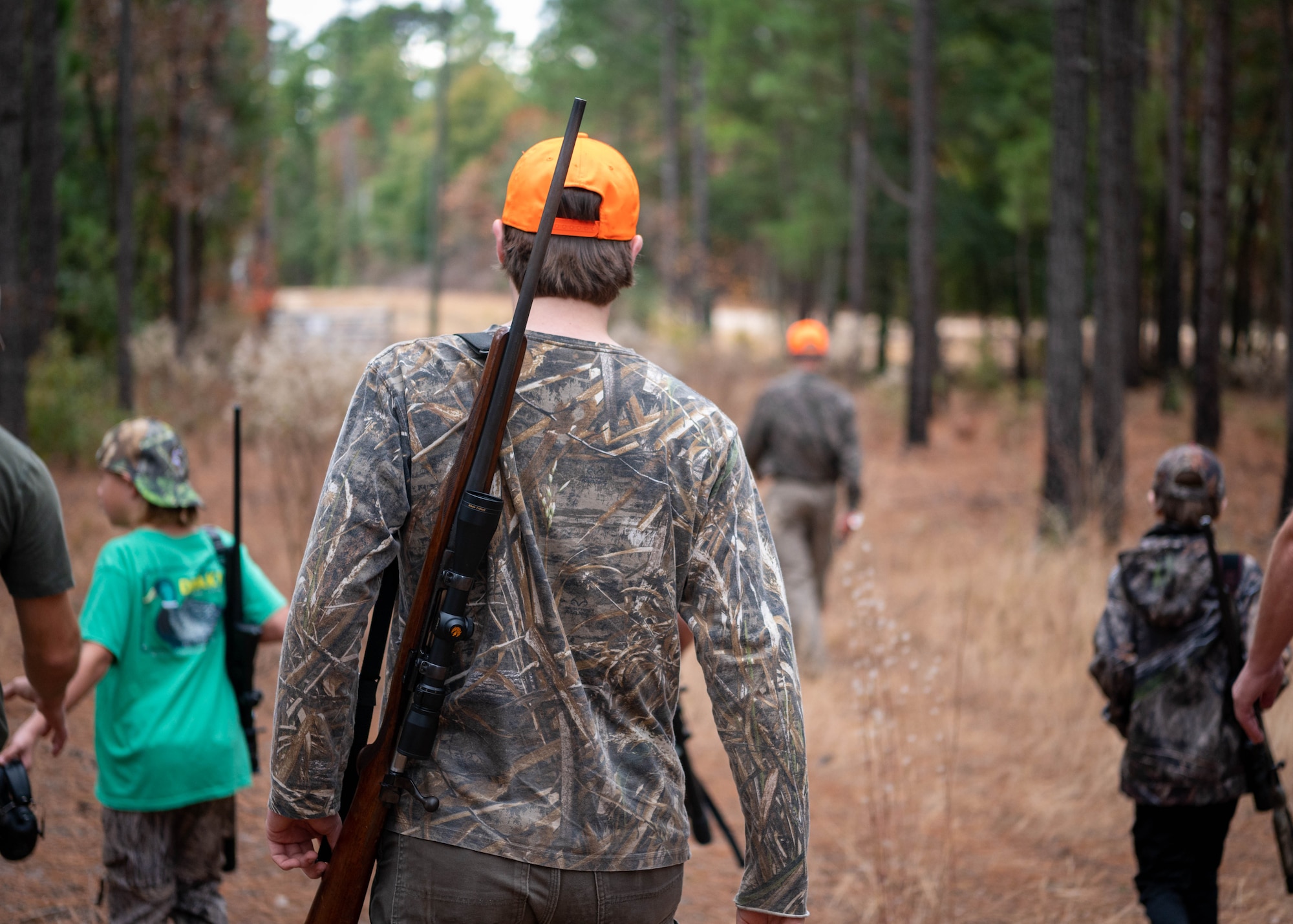 Participants in a youth hunting event spproach a firing range to calibrate their rifle sights.