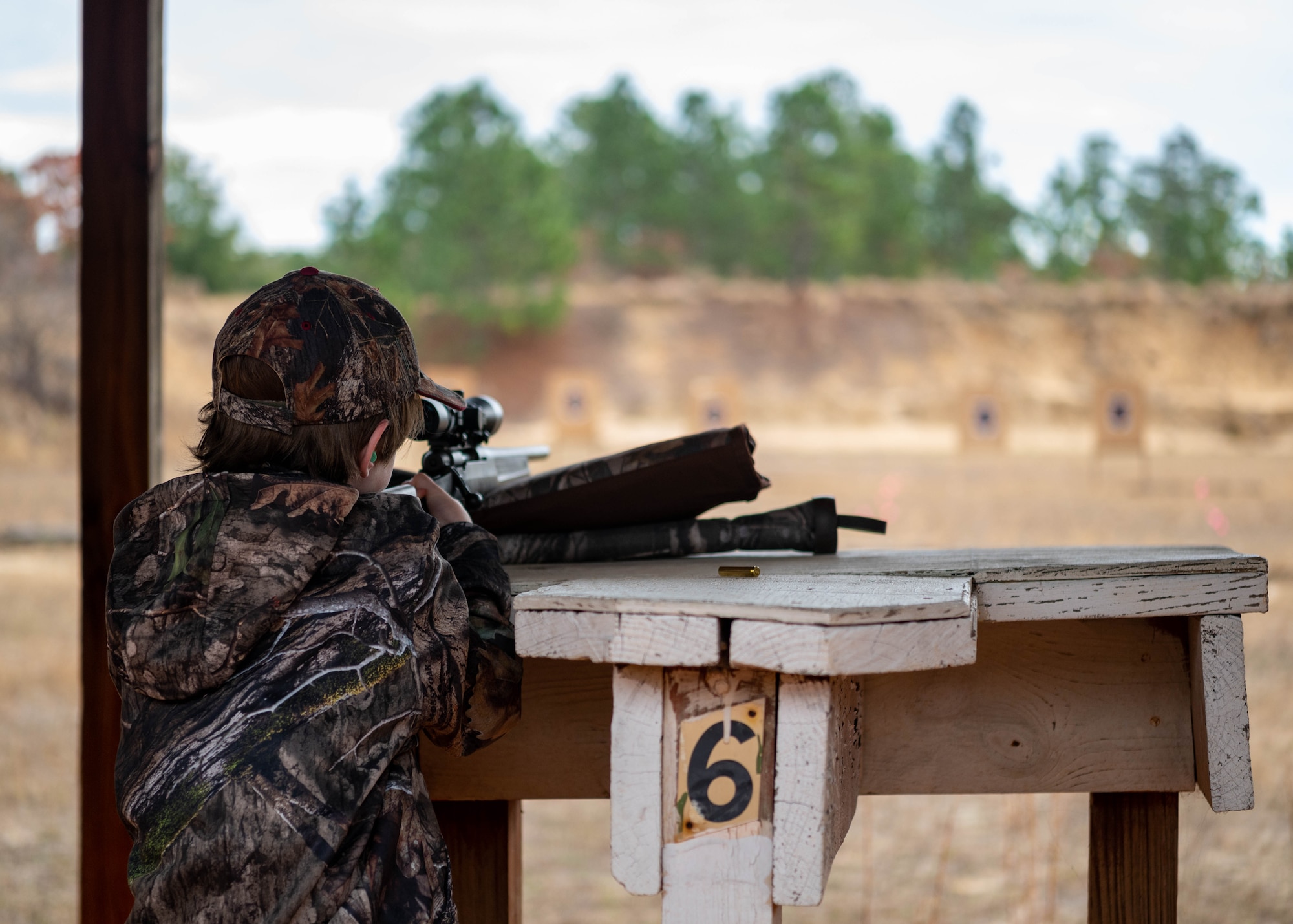 A youth hunting event participant calibrates their rifle sights.