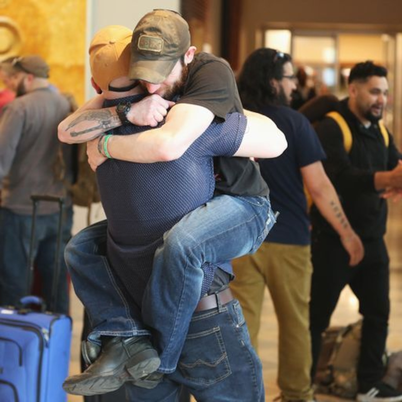 Two men hug.