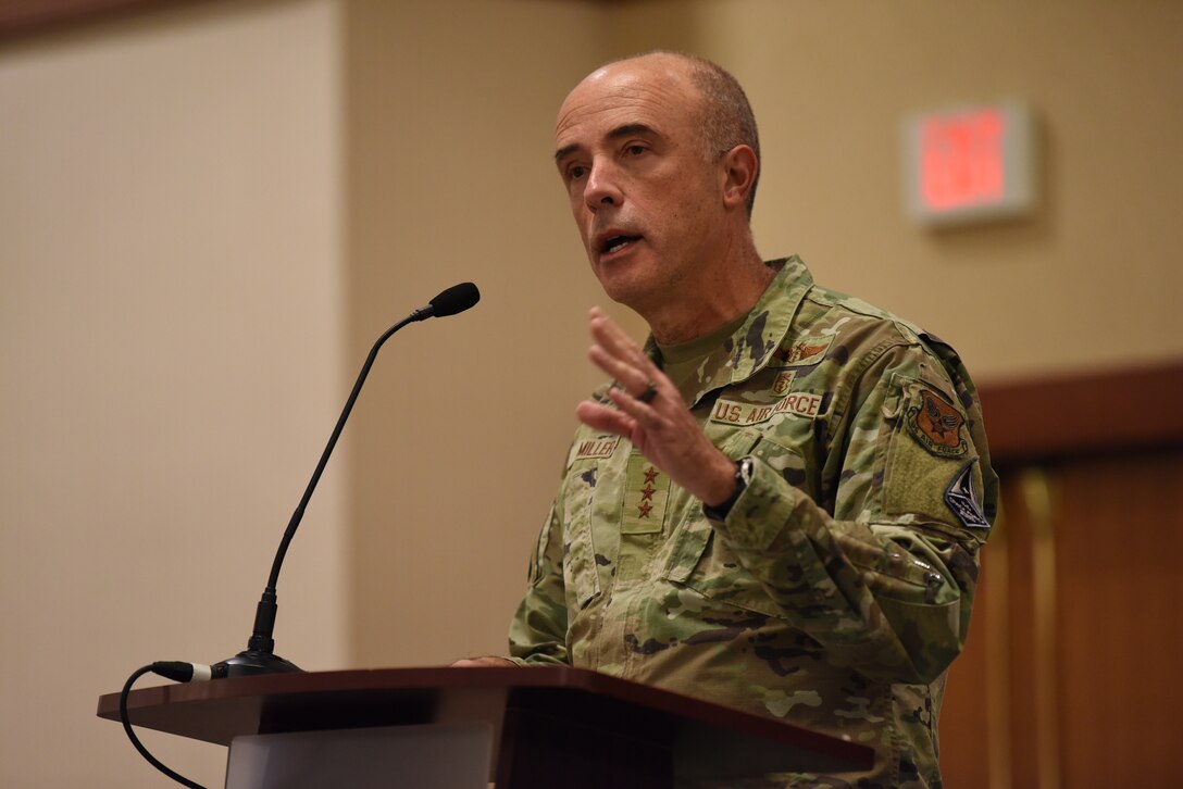 Image of an Airman speaking at a podium.
