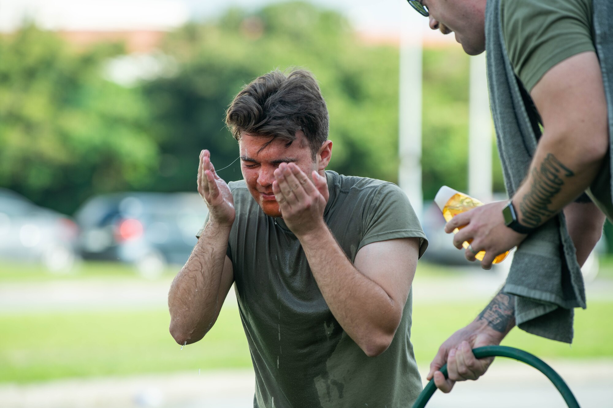 Defender washes OC spray off his face.