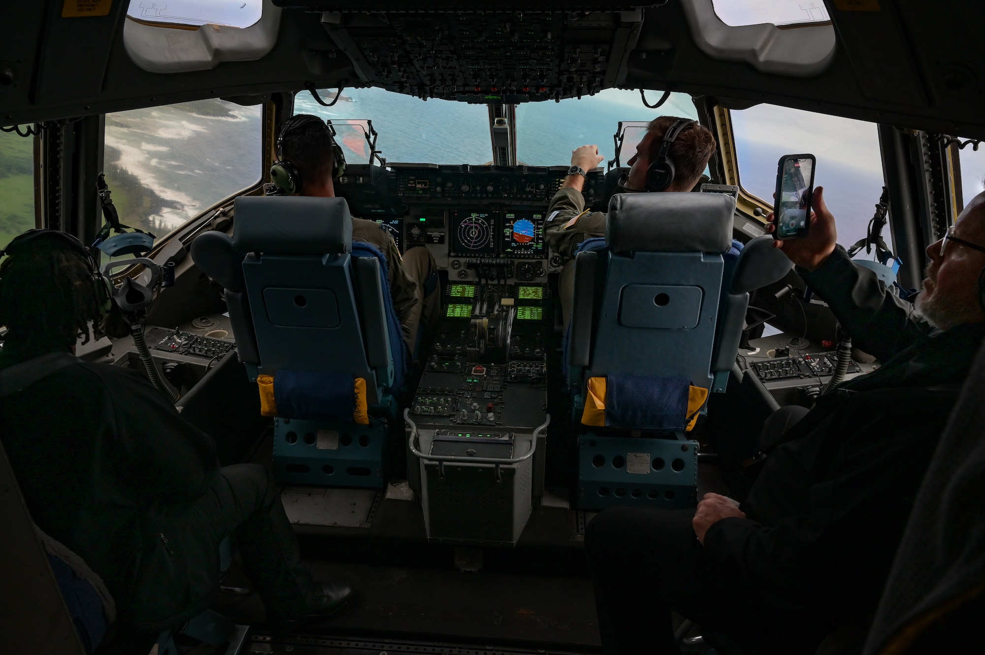 Capt. Giovanni Allevato, 535th Airlift Squadron C-17 Globemaster III pilot, and 1st Lt. Christian Nasto, 535th AS C-17 co-pilot, speak to Executive Leadership Development Program participants during an orientation flight over the Hawaiian Islands, Dec. 6, 2022. Nearly 70 senior government officials were familiarized with the aircraft’s mission operations and capabilities during the flight. (U.S. Air Force photo by Staff Sgt. Alan Ricker)