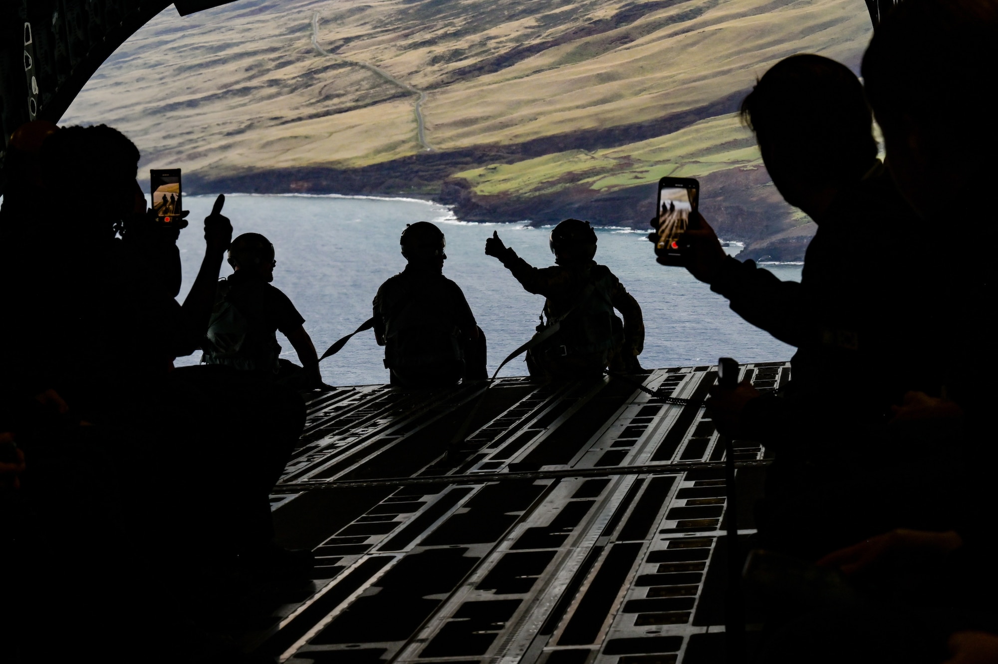 Senior Airman Anthony Wagnon, 535th Airlift Squadron loadmaster, rides on the ramp with Executive Leadership Development Program participants during an orientation flight over the Hawaiian Islands, Dec. 6, 2022. ELDP participants met with 15th Wing leadership before the flight to learn about the Wing’s mission. (U.S. Air Force photo by Staff Sgt. Alan Ricker)
