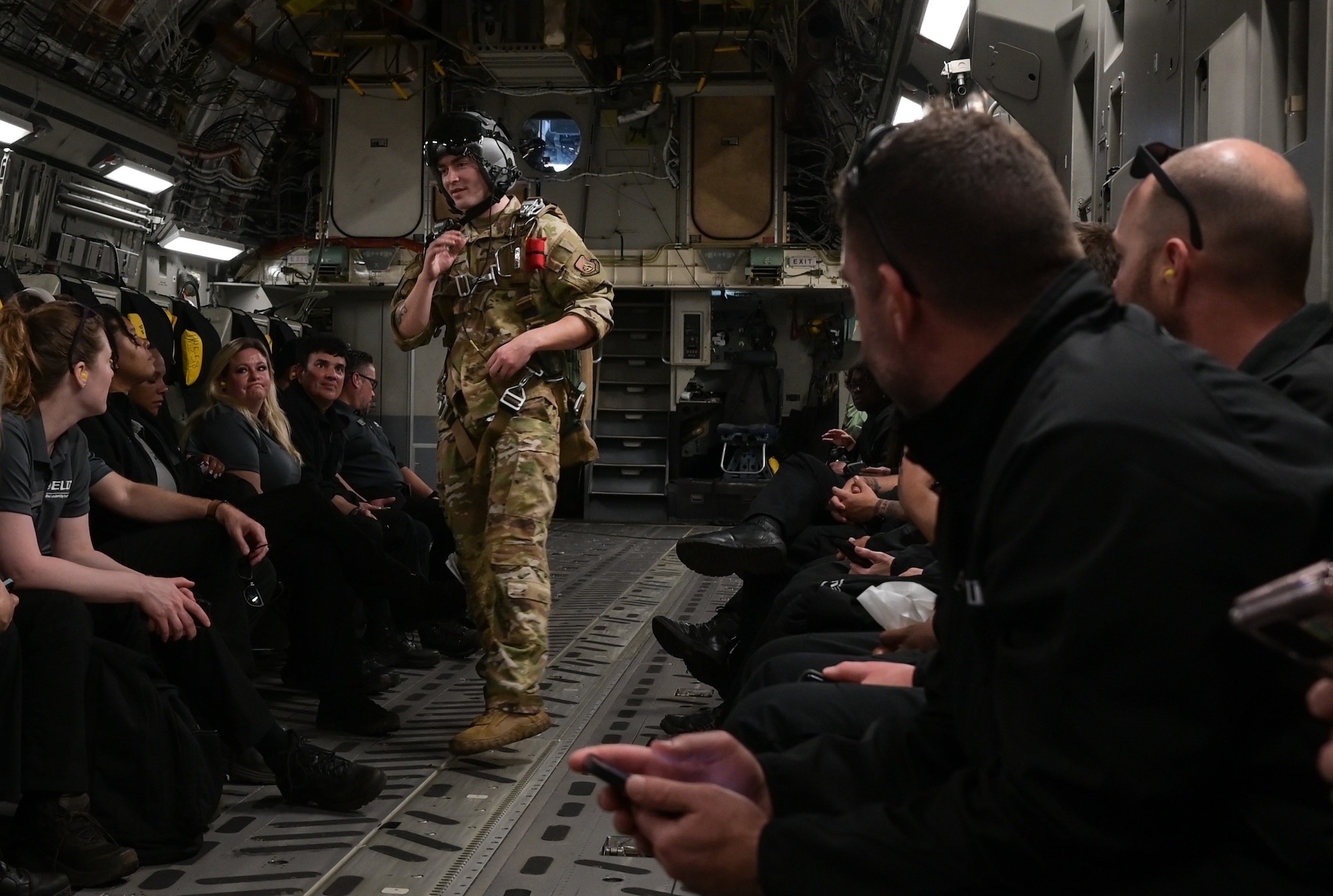 Senior Airmen Duke Edens, 535th Airlift Squadron loadmaster, speaks to Executive Leadership Development Program participants during an orientation flight over the Hawaiian Islands, Dec. 6, 2022. ELDP participants were given the opportunity to see the C-17 Globemaster III operate first-hand by sitting in the flight deck and the fuselage during the flight. (U.S. Air Force photo by Staff Sgt. Alan Ricker)