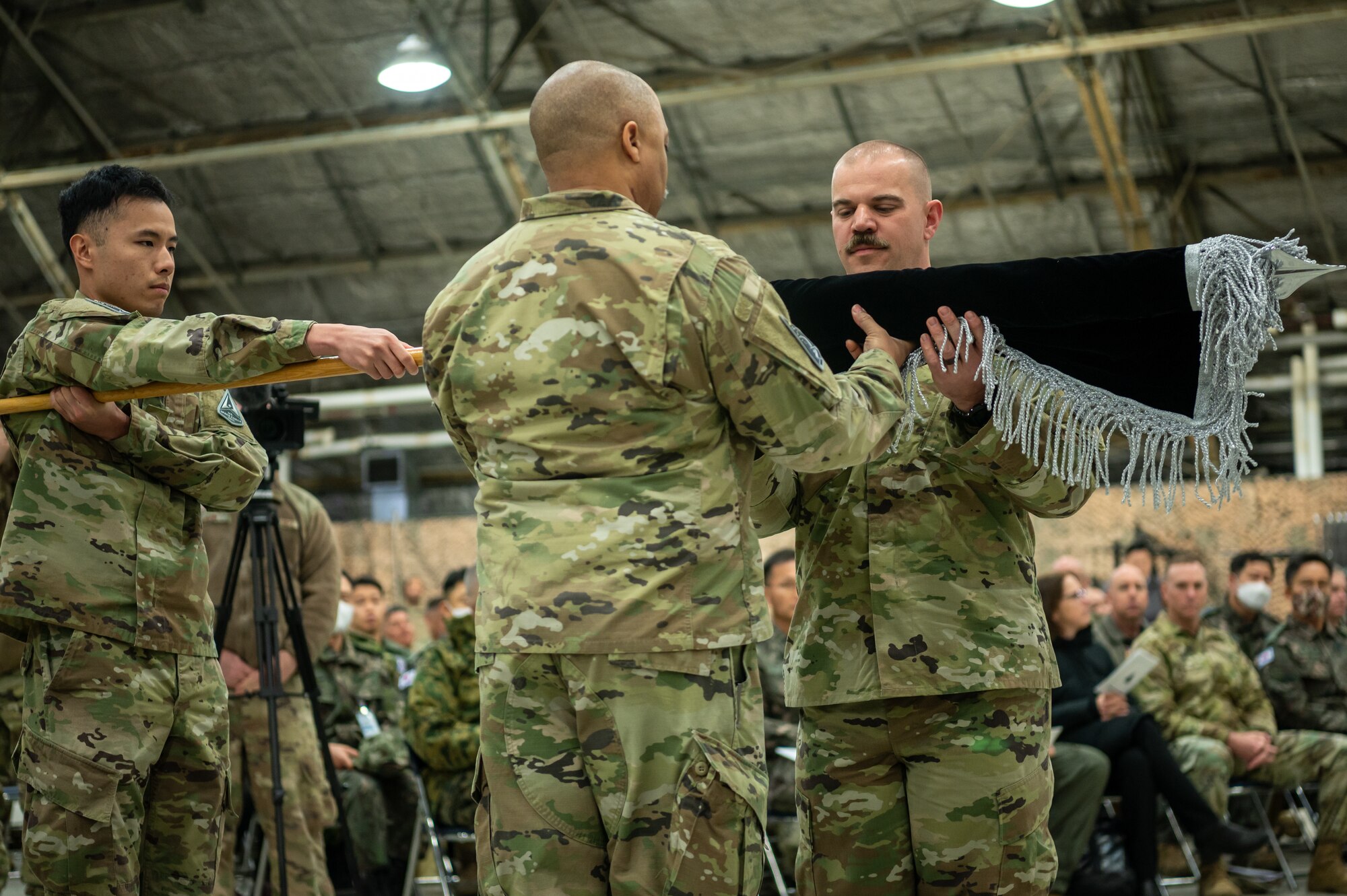 U.S. Space Force Lt. Col. Joshua McCullion, U.S. Space Forces Korea inaugural commander, unfurls the USSFK flag during the unit’s activation ceremony at Osan Air Base, Republic of Korea, Dec. 14, 2022.